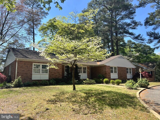 single story home featuring brick siding and a front yard