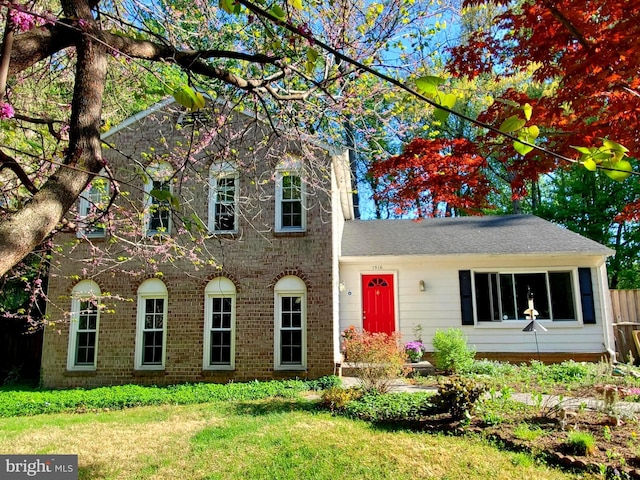 view of front facade featuring brick siding and a front lawn