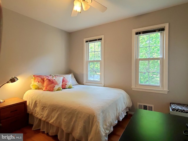 bedroom with visible vents, ceiling fan, and wood finished floors