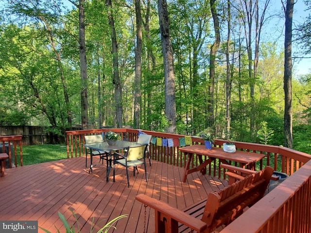 wooden deck with outdoor dining area and fence
