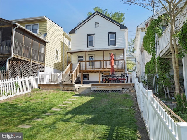 back of house featuring a lawn, a fenced backyard, and a sunroom