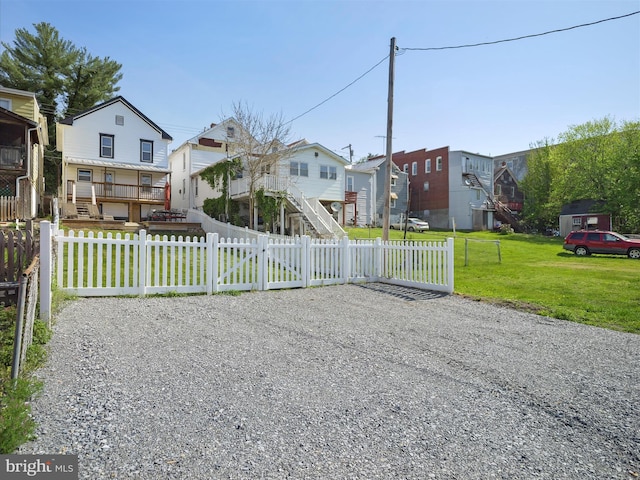 view of front of home featuring a front lawn, a fenced front yard, and a residential view