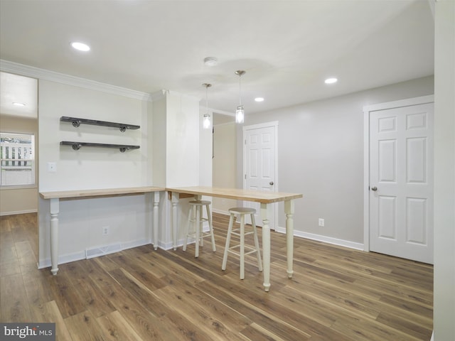 kitchen featuring visible vents, ornamental molding, baseboards, and dark wood-style floors
