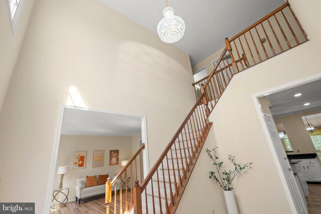 13423 Fairland Park Dr, Silver Spring, MD 20904 - stairway with an inviting chandelier, recessed lighting, a towering ceiling, and wood finished floors