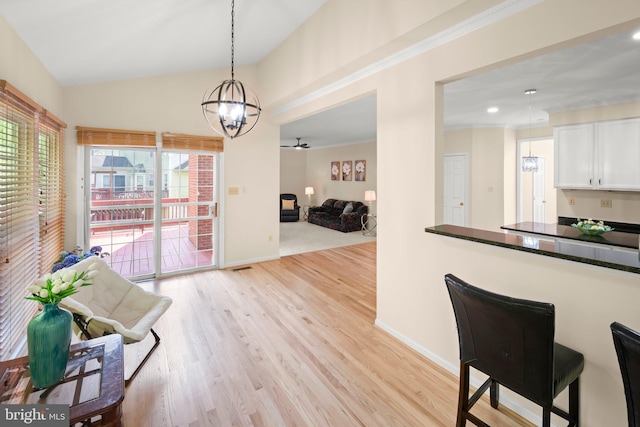 13423 Fairland Park Dr, Silver Spring, MD 20904 - kitchen with dark countertops, hanging light fixtures, a chandelier, light wood-style flooring, and white cabinetry