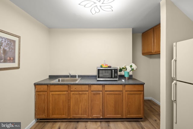 13423 Fairland Park Dr, Silver Spring, MD 20904 - kitchen featuring freestanding refrigerator, dark countertops, light wood-style floors, stainless steel microwave, and a sink