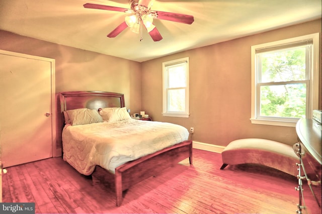 bedroom with baseboards, wood-type flooring, and a ceiling fan