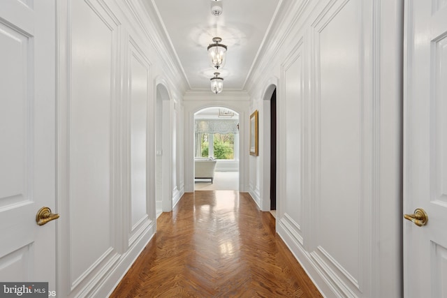 hall with arched walkways, ornamental molding, and a decorative wall