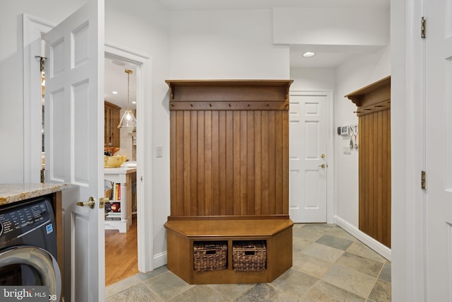 mudroom featuring stone finish flooring, washer / dryer, and baseboards