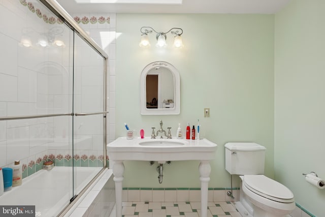 bathroom with toilet, tiled shower / bath combo, and a sink