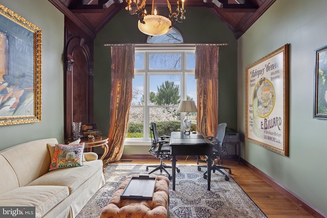 home office with a chandelier, vaulted ceiling, wood finished floors, and baseboards