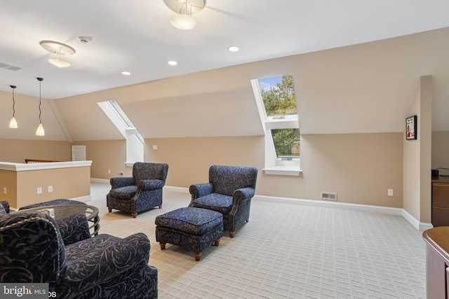 interior space featuring baseboards, visible vents, vaulted ceiling with skylight, and light colored carpet