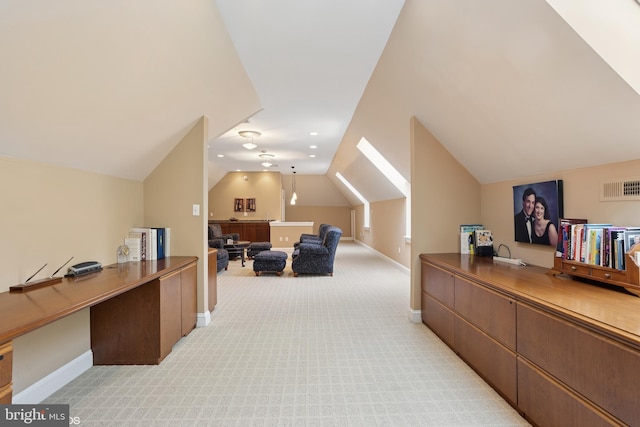 interior space featuring light colored carpet, visible vents, vaulted ceiling, and baseboards