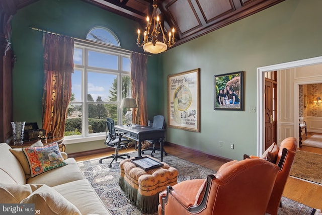 office area featuring baseboards, wood finished floors, and an inviting chandelier