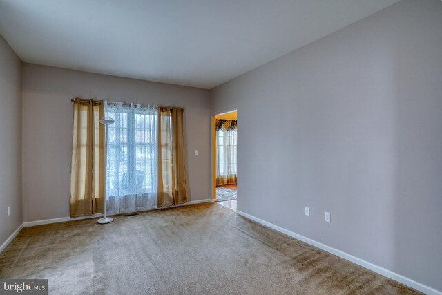 carpeted empty room with baseboards and visible vents