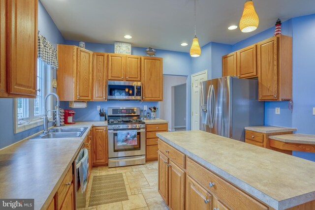 kitchen featuring appliances with stainless steel finishes, light countertops, stone finish flooring, a sink, and pendant lighting