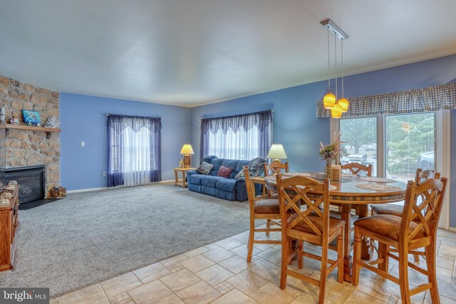 dining space featuring a fireplace and light colored carpet