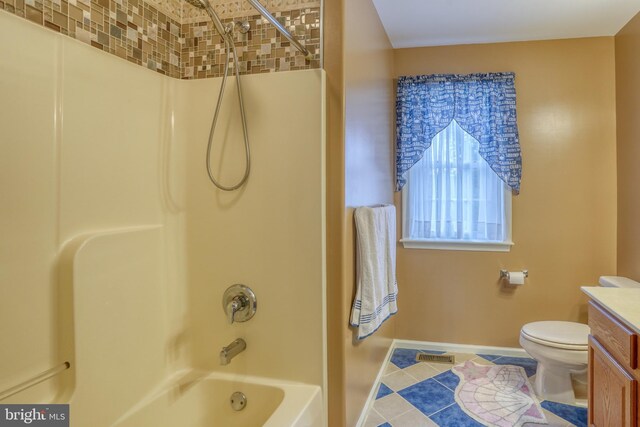 bathroom featuring washtub / shower combination, vanity, tile patterned floors, toilet, and baseboards