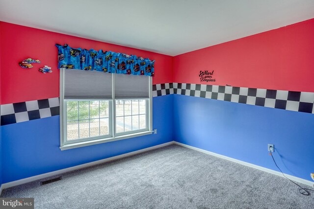 unfurnished room featuring visible vents and carpet flooring