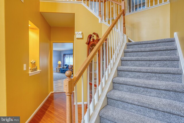 stairway with wood finished floors and baseboards