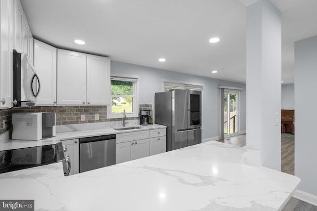 kitchen featuring a sink, appliances with stainless steel finishes, tasteful backsplash, and recessed lighting