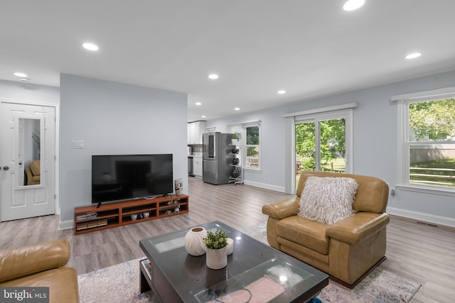 living area featuring baseboards, recessed lighting, and light wood-style flooring