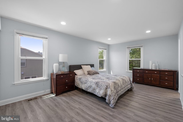 bedroom with visible vents, recessed lighting, baseboards, and wood finished floors