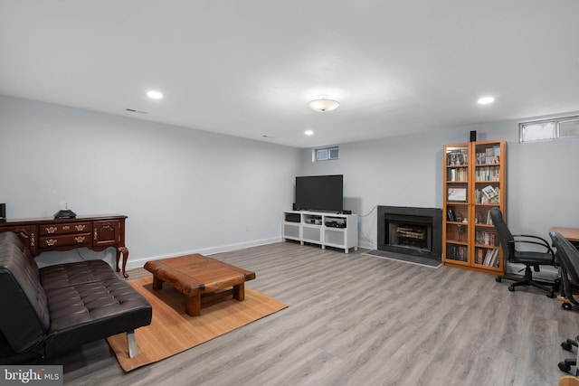 living area featuring baseboards, a fireplace, recessed lighting, and wood finished floors