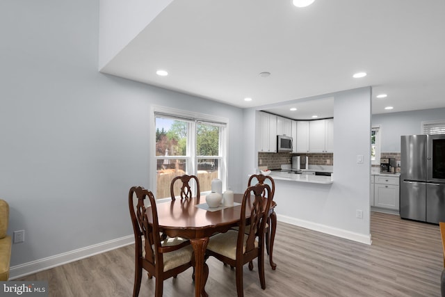 dining room with baseboards, recessed lighting, and light wood finished floors