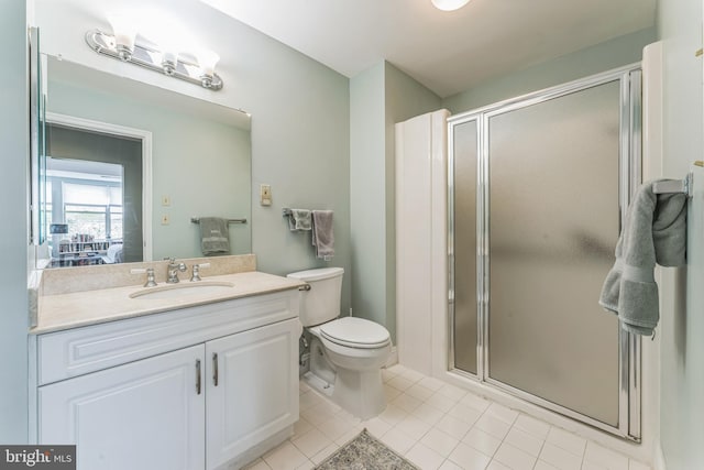 full bathroom featuring vanity, toilet, tile patterned flooring, and a stall shower