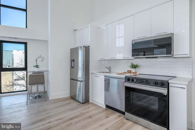4328 Georgia Ave NW Unit 401, Washington, DC 20011 - kitchen with light countertops, light wood finished floors, appliances with stainless steel finishes, and a sink