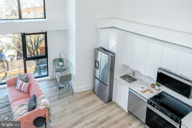 4328 Georgia Ave NW Unit 401, Washington, DC 20011 - kitchen featuring dishwasher, light wood finished floors, light countertops, stainless steel refrigerator with ice dispenser, and white cabinetry