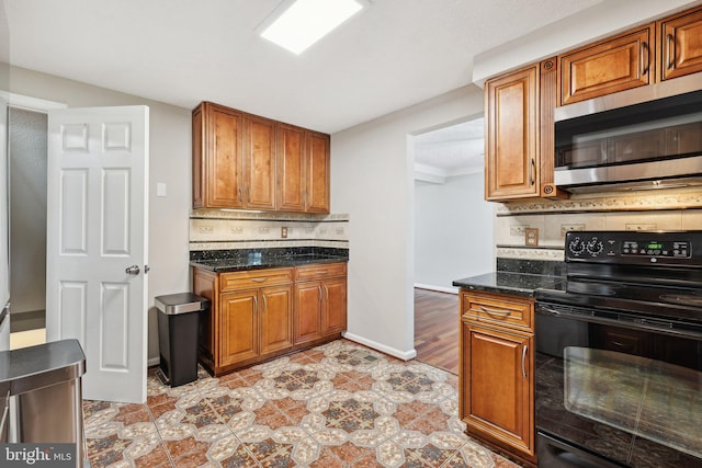 7112 Bonniemill Ln, Springfield, VA 22150 - kitchen with stainless steel microwave, black electric range oven, tasteful backsplash, brown cabinets, and ornamental molding