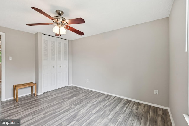 7112 Bonniemill Ln, Springfield, VA 22150 - unfurnished bedroom featuring wood finished floors, a closet, baseboards, and a ceiling fan