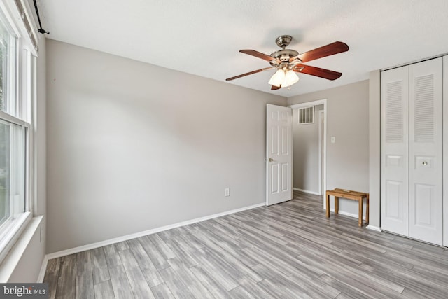 7112 Bonniemill Ln, Springfield, VA 22150 - unfurnished bedroom featuring multiple windows, light wood-style floors, a closet, and baseboards