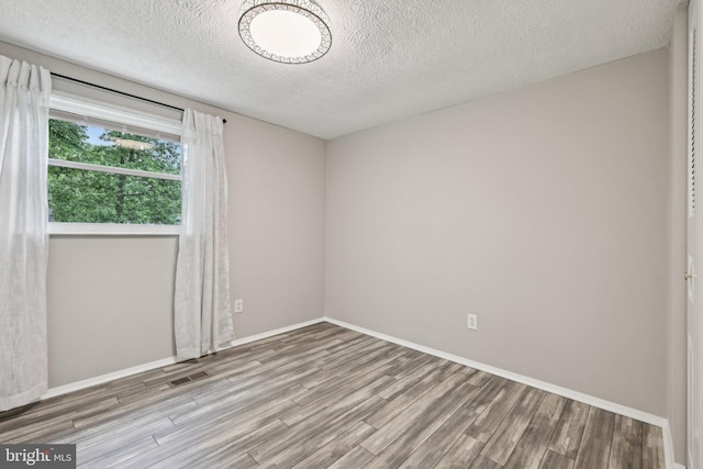 7112 Bonniemill Ln, Springfield, VA 22150 - spare room with wood finished floors, baseboards, and a textured ceiling