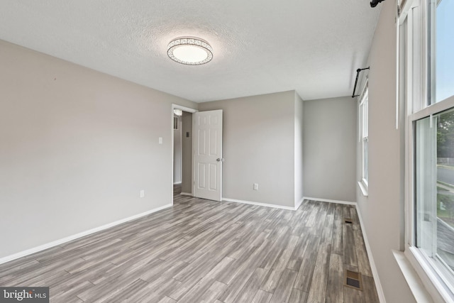 7112 Bonniemill Ln, Springfield, VA 22150 - unfurnished room with wood finished floors, baseboards, and a textured ceiling