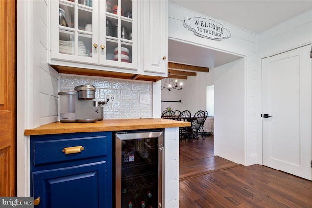 bar with dark wood-type flooring, backsplash, and beverage cooler