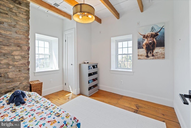 bedroom with baseboards, hardwood / wood-style flooring, beamed ceiling, and multiple windows
