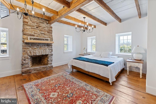 bedroom featuring beam ceiling, baseboards, a notable chandelier, and wood-type flooring