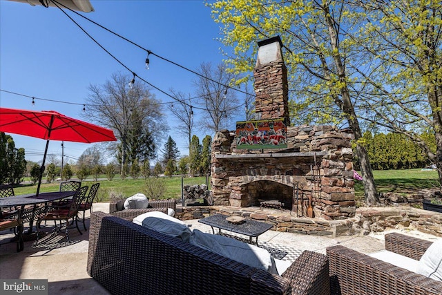 view of patio / terrace with an outdoor living space with a fireplace and outdoor dining area