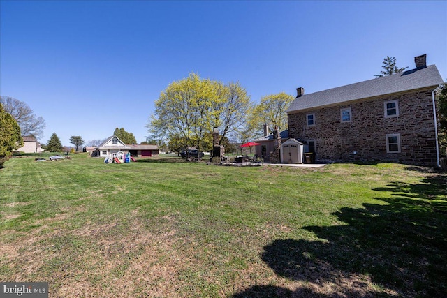 view of yard featuring an outbuilding and a shed