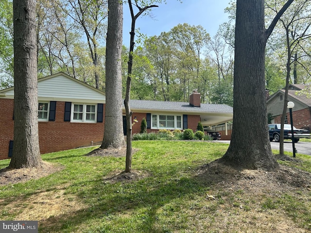 13709 Wendover Rd, Silver Spring, MD 20904 - view of front of home featuring brick siding, a chimney, a front lawn, and an attached carport