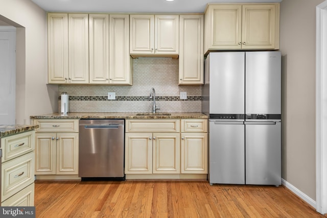 13709 Wendover Rd, Silver Spring, MD 20904 - kitchen featuring appliances with stainless steel finishes, cream cabinets, a sink, and backsplash