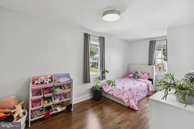 bedroom with wood finished floors and baseboards