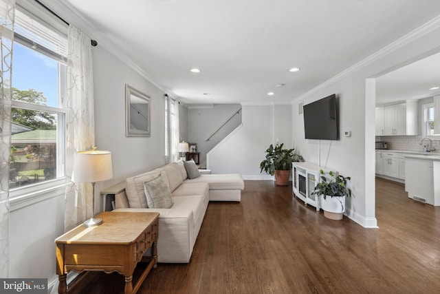 living area with ornamental molding, recessed lighting, wood finished floors, and baseboards