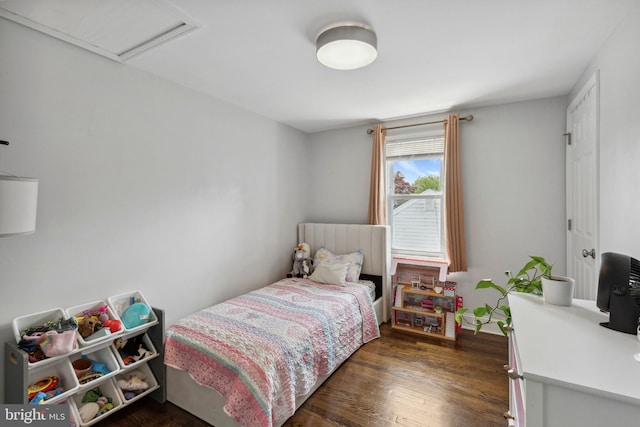 bedroom with dark wood-style floors and attic access