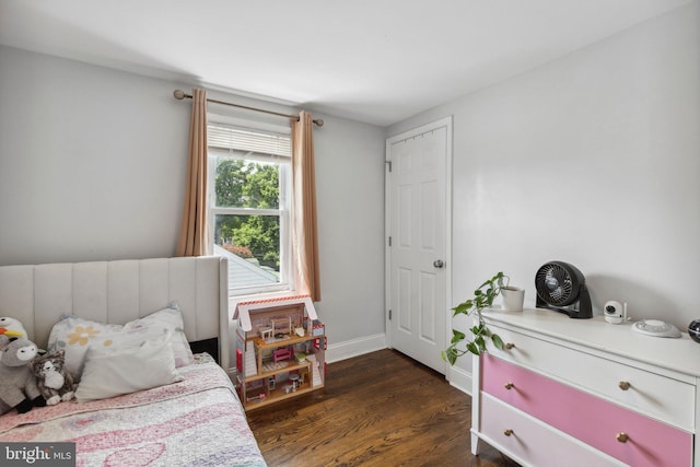bedroom with dark wood-type flooring and baseboards