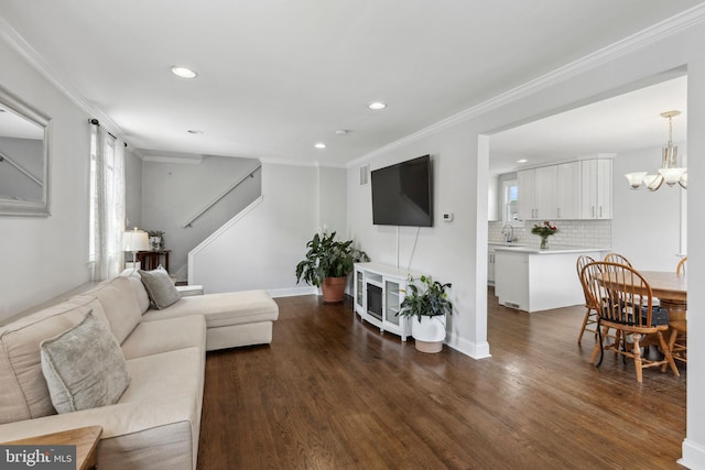 living area with recessed lighting, dark wood-style flooring, a chandelier, crown molding, and baseboards