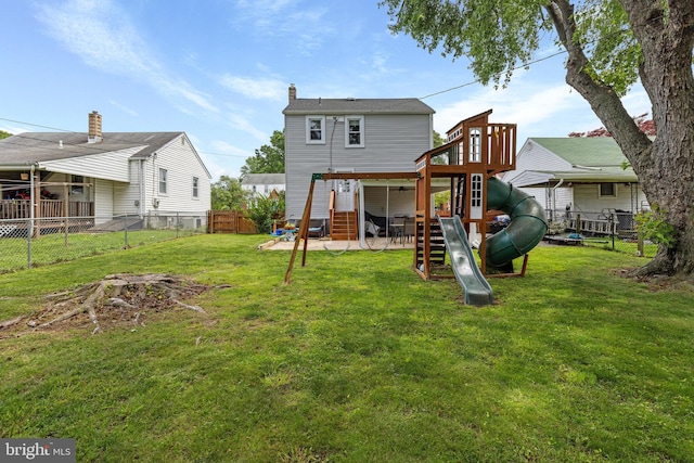rear view of property featuring a playground